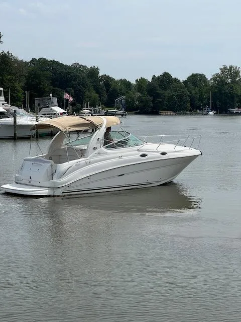 Slide: The Image of 2005 Sea Ray 280 Sundancer boat on calm lake with trees in background. - 3