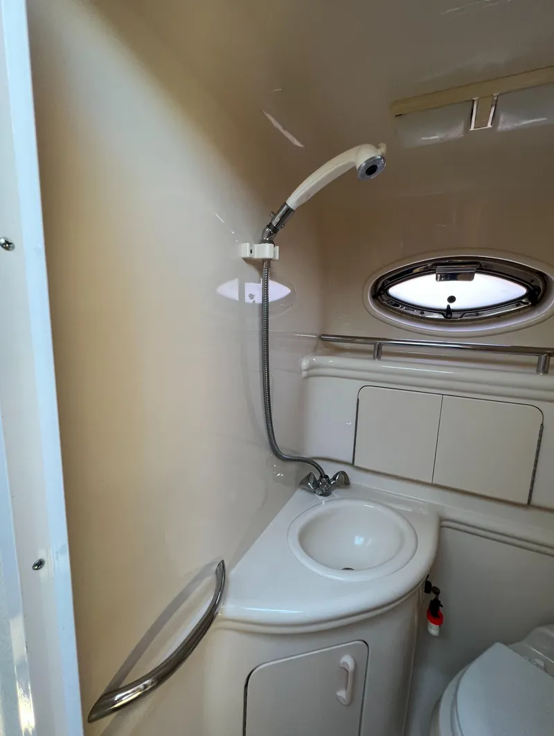 Slide: The Image of 2005 Sea Ray 280 Sundancer bathroom with sink, shower, and porthole window. - 31