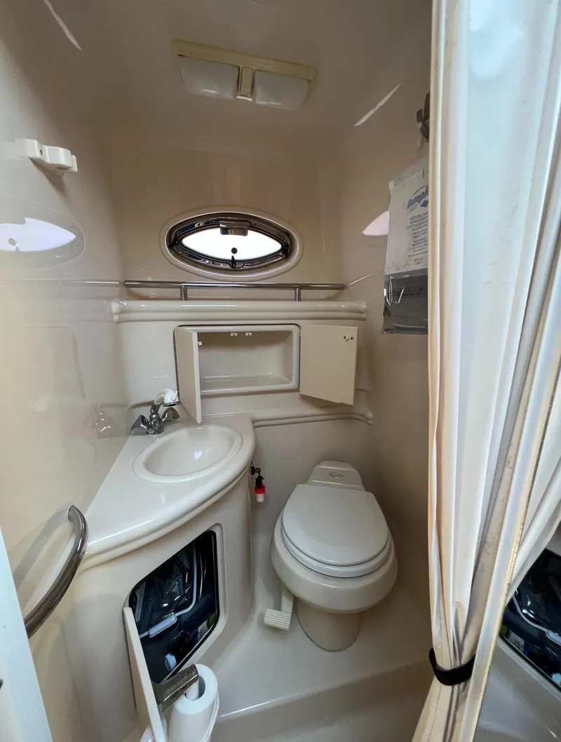 Slide: The Image of 2005 Sea Ray 280 Sundancer bathroom with sink, toilet, and porthole window. - 32