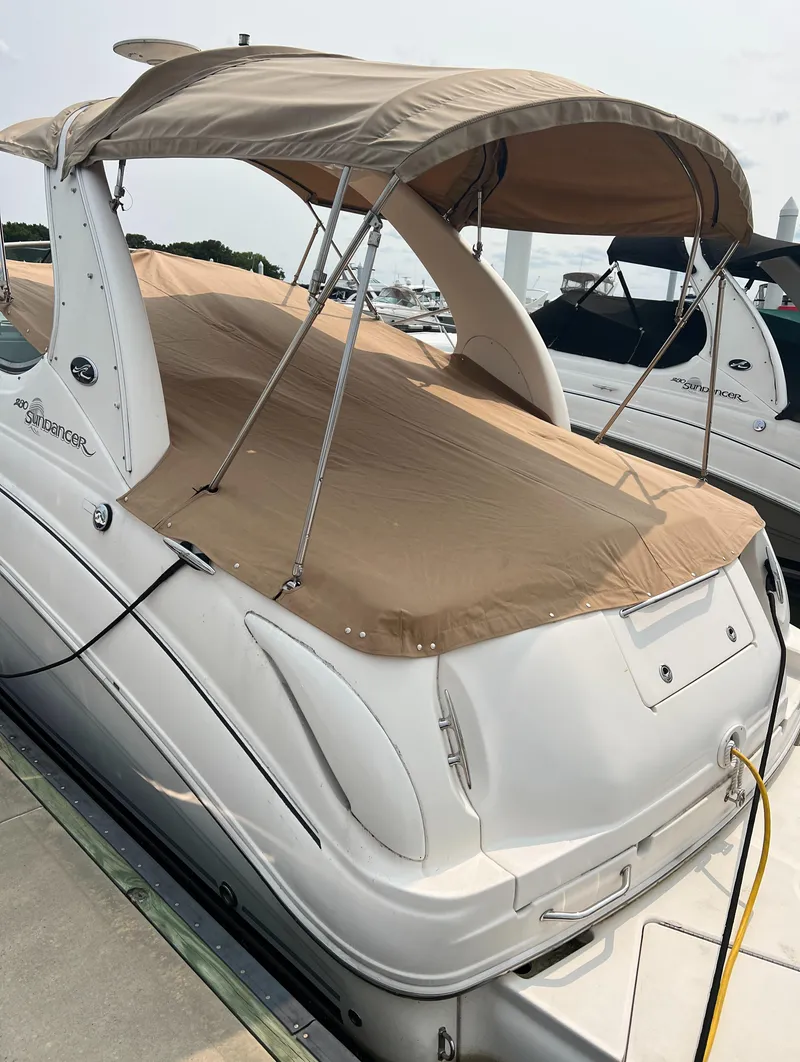 Slide: The Image of 2005 Sea Ray 280 Sundancer boat with beige canopy docked at marina. - 5