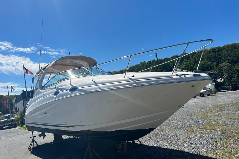 Slide: The Image of 2005 Sea Ray 280 Sundancer boat on land under clear blue sky. - 6