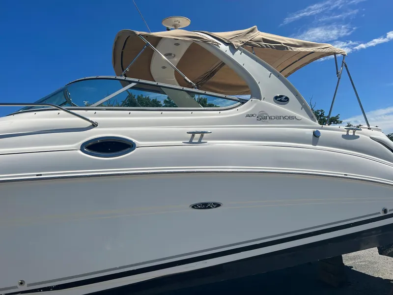 Slide: The Image of 2005 Sea Ray 280 Sundancer boat with beige canopy under clear blue sky. - 9