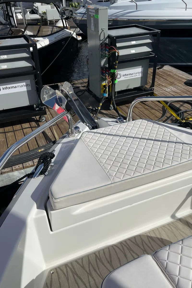 Slide: The Image of 2025 Jeanneau DB/37 OB boat with quilted seating at a marina dock. - 11