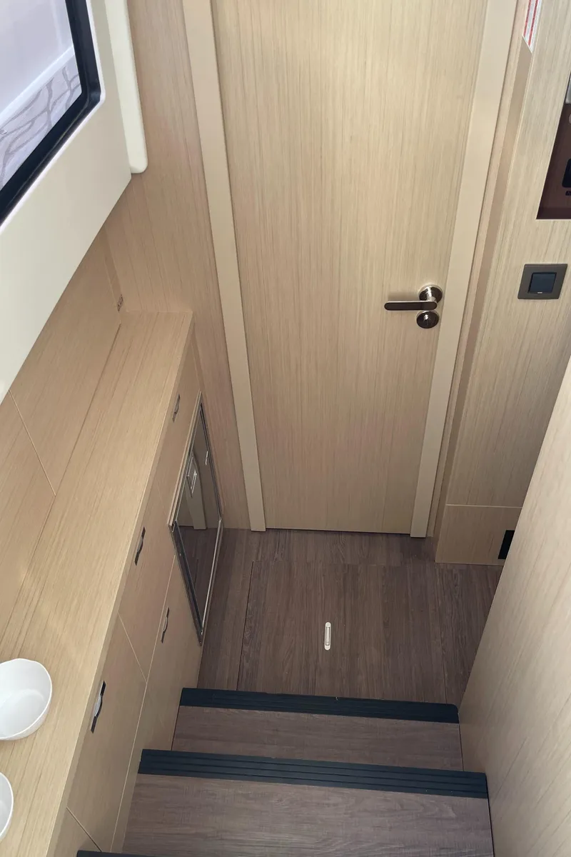 Slide: The Image of Interior of 2025 Jeanneau DB/37 OB yacht with wooden stairs and door. - 12