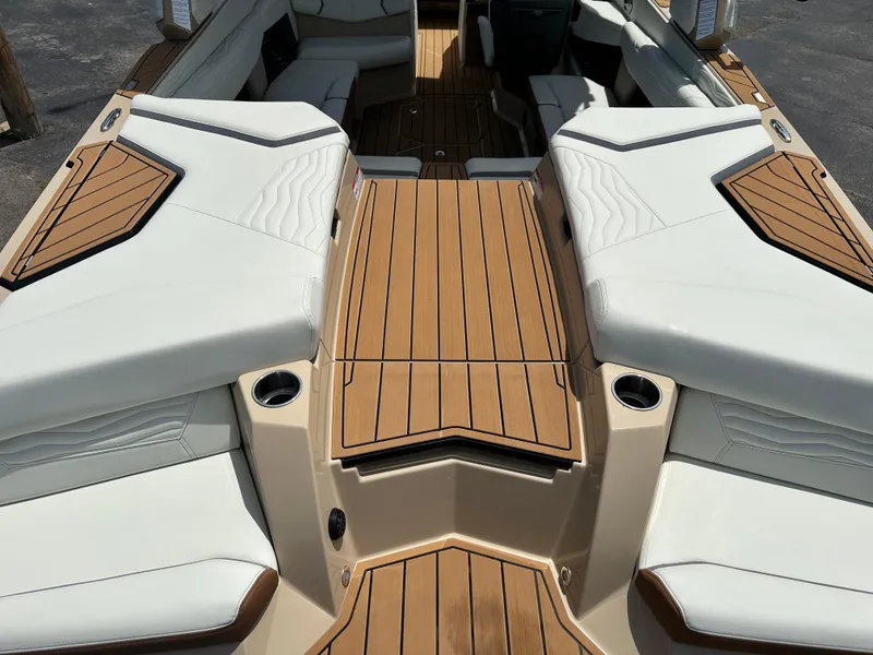 Slide: The Image of 2025 Nautique Super Air Nautique G23 boat interior with teak decking and white seating. - 13