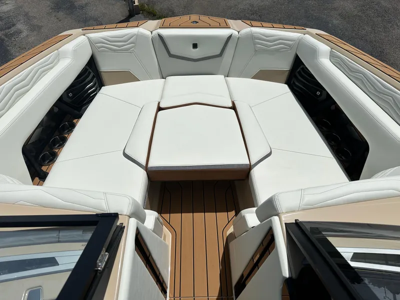 Slide: The Image of 2025 Nautique Super Air Nautique G23 boat interior with luxurious white seating and teak flooring. - 17