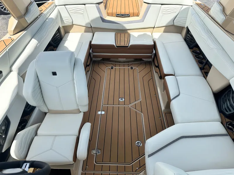 Slide: The Image of 2025 Nautique Super Air Nautique G23 interior with luxurious seating and teak flooring. - 18