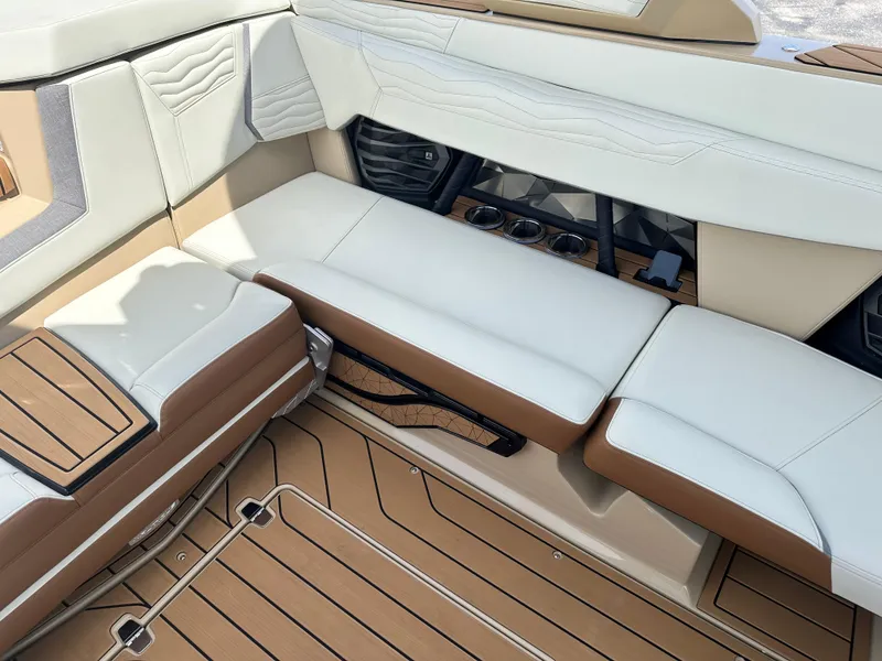 Slide: The Image of 2025 Nautique Super Air Nautique G23 interior with beige and brown seating and flooring. - 19