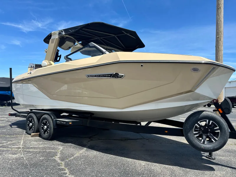 Slide: The Image of 2025 Nautique Super Air Nautique G23 boat on trailer under clear blue sky. - 4