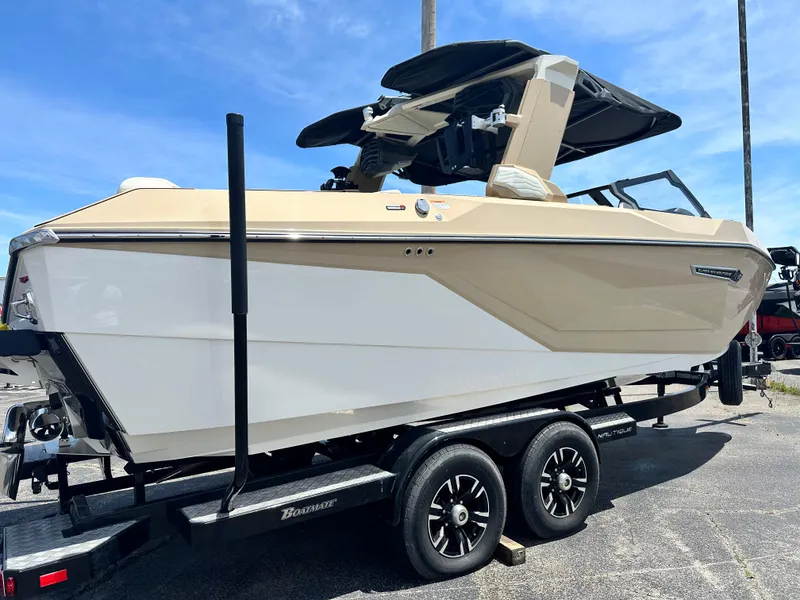 Slide: The Image of 2025 Nautique Super Air Nautique G23 boat on trailer, beige and white design, sunny day. - 5