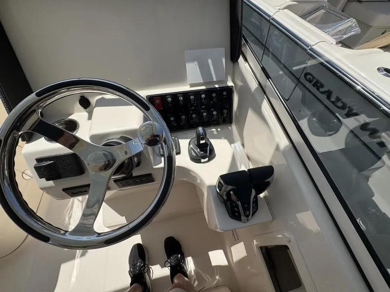 Slide: The Image of Helm of 2025 Grady-White Freedom 275 boat with steering wheel and control panel. - 11