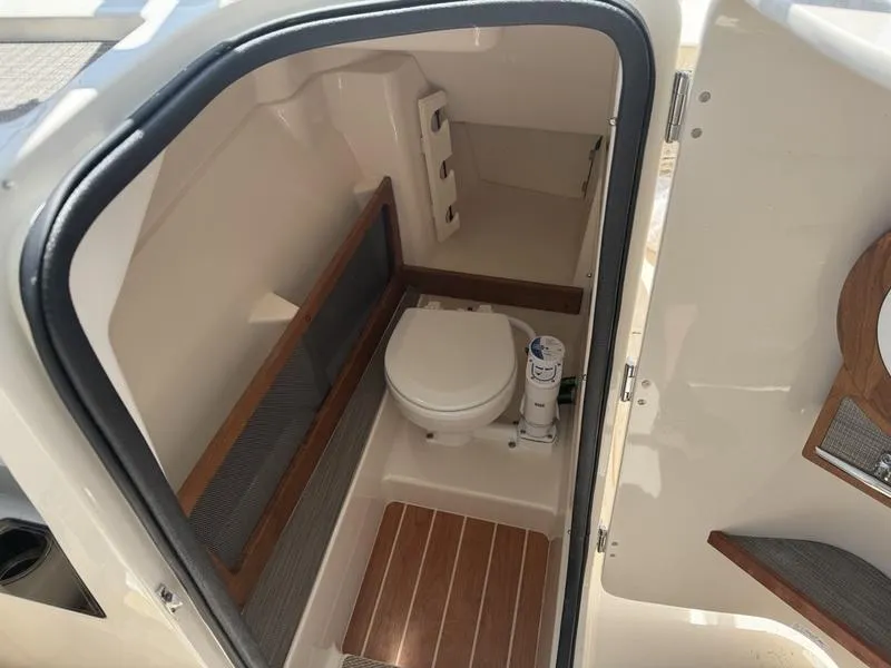 Slide: The Image of 2025 Grady-White Freedom 275 boat interior with compact marine toilet. - 3