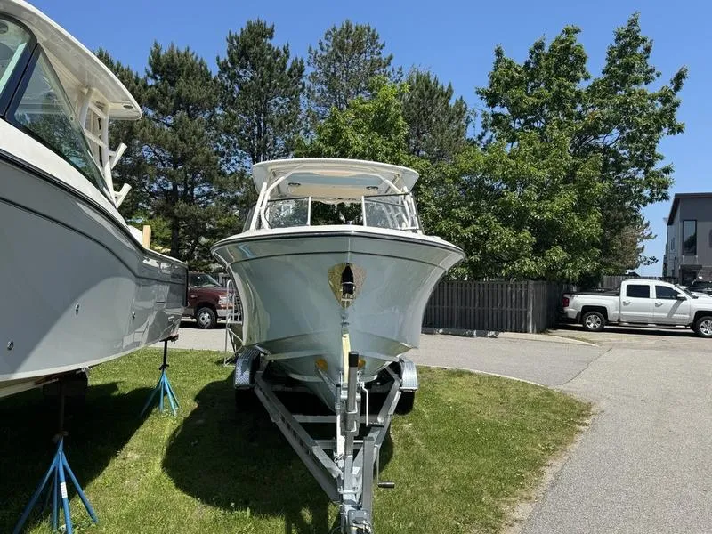 Slide: The Image of 2025 Grady-White Freedom 275 boat on trailer, parked outdoors under clear blue sky. - 4