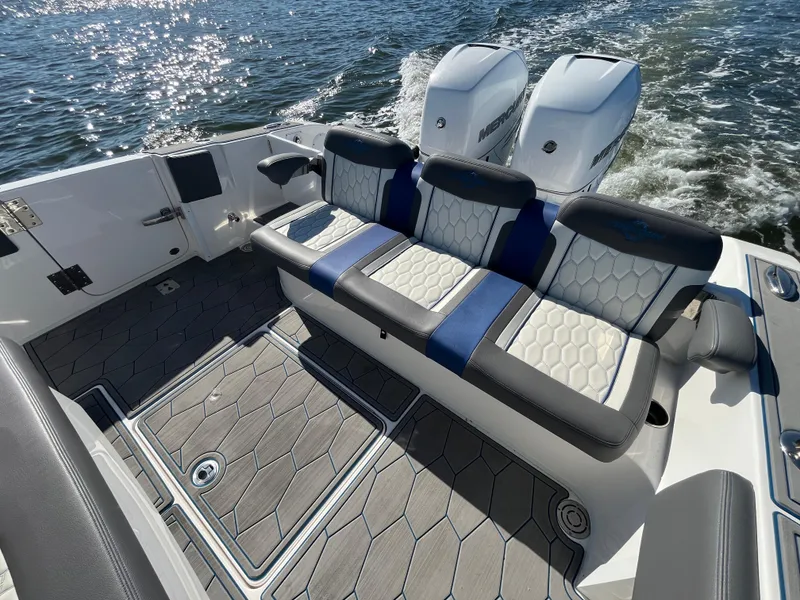 Slide: The Image of 2022 Fountain 34 SC boat interior with cushioned seating and twin engines on the water. - 12