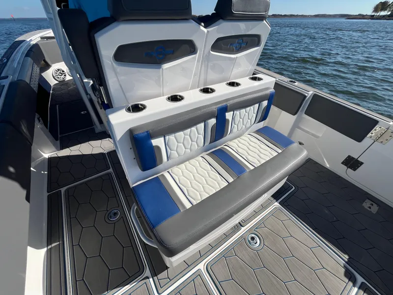 Slide: The Image of 2022 Fountain 34 SC boat interior with stylish seating and cup holders on the water. - 14