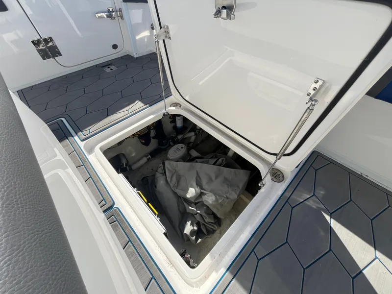 Slide: The Image of Open storage compartment on 2022 Fountain 34 SC boat with hexagonal floor pattern. - 16