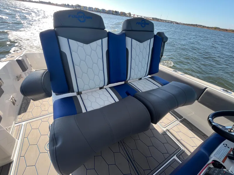 Slide: The Image of 2022 Fountain 34 SC boat seats with blue and white upholstery on the water. - 23