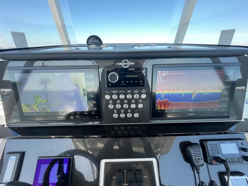 Slide: The Image of 2022 Fountain 34 SC boat dashboard with dual navigation screens and controls. - 26