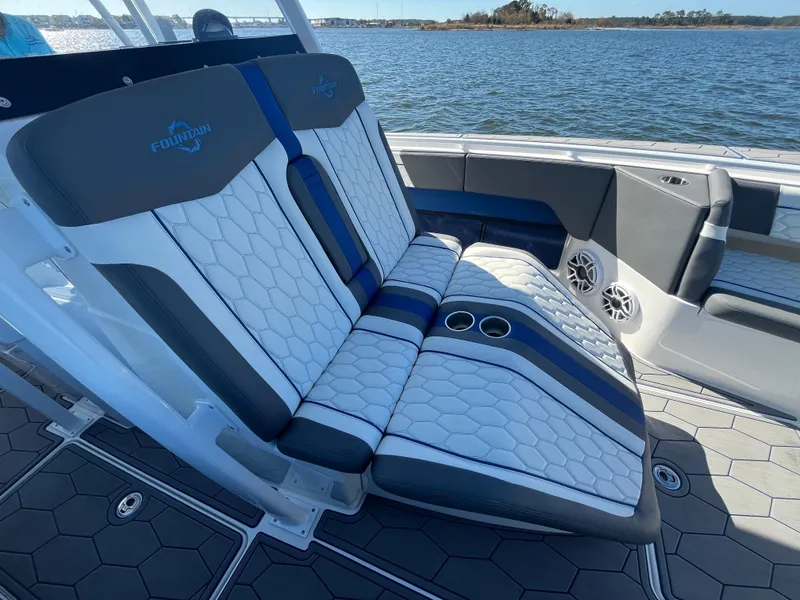 Slide: The Image of 2022 Fountain 34 SC boat interior with stylish seating and cup holders by the water. - 34