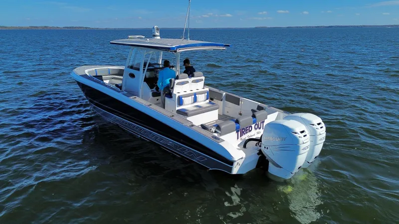 Slide: The Image of 2022 Fountain 34 SC boat cruising on open water, featuring twin outboard engines. - 5