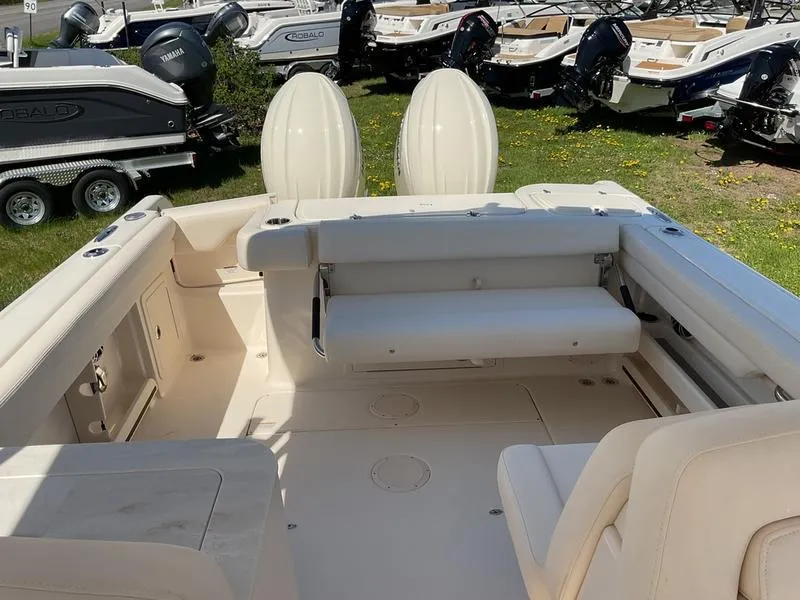 Slide: The Image of 2025 Grady-White Freedom 275 boat on trailer, parked on grassy area, sunny day. - 2