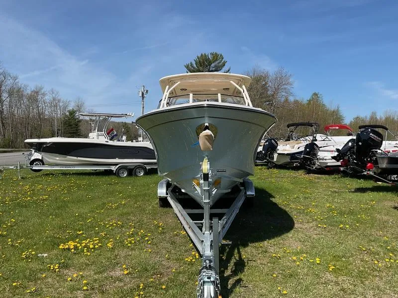 Slide: The Image of 2025 Grady-White Freedom 275 boat on trailer, parked on grassy area under clear sky. - 3