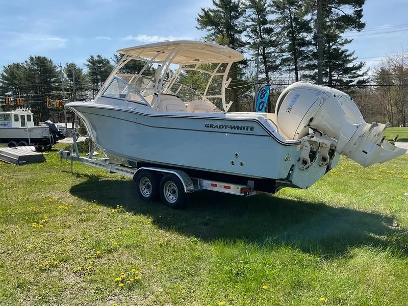 Slide: The Image of 2025 Grady-White Freedom 275 boat on trailer, parked on grassy field under clear sky. - 4