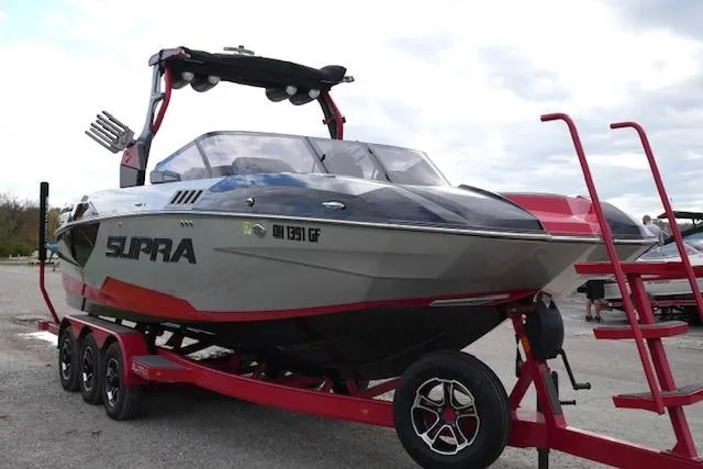 Slide: The Image of 2021 Supra SE 450 boat on red trailer, parked outdoors. - 4