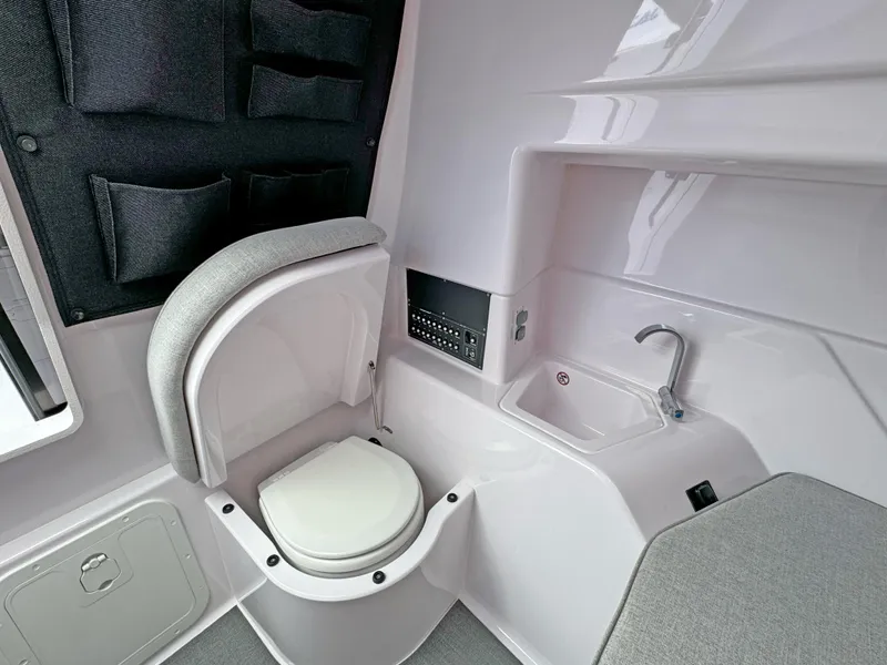 Slide: The Image of 2025 Axopar 25 Cross Top boat interior with compact toilet and sink. - 13