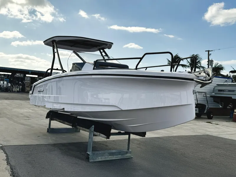 Slide: The Image of 2025 Axopar 25 Cross Top boat displayed outdoors on a stand. - 3