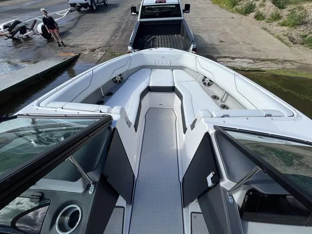 Slide: The Image of 2025 Regal LS4 boat interior with white seating, docked near a pickup truck. - 29