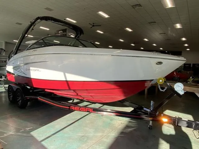 Slide: The Image of 2025 Regal LS4 boat with red and white design on a trailer in a showroom. - 3
