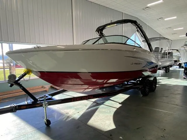 Slide: The Image of 2025 Regal LS4 boat with red hull on trailer in showroom. - 4