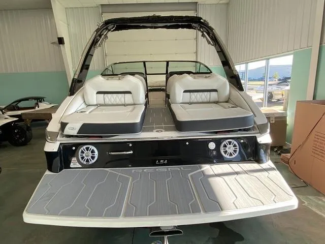 Slide: The Image of 2025 Regal LS4 boat with sleek design and comfortable seating in a showroom. - 6