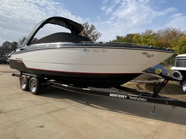 Slide: The Image of 2017 Monterey 278SS boat on trailer, parked outdoors under a partly cloudy sky. - 2