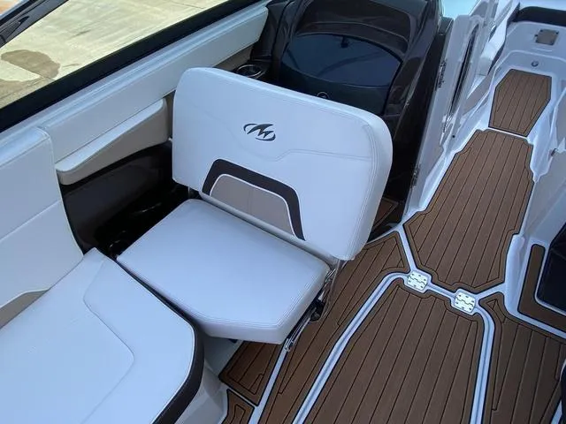 Slide: The Image of 2017 Monterey 278SS boat interior with white seating and brown deck flooring. - 25