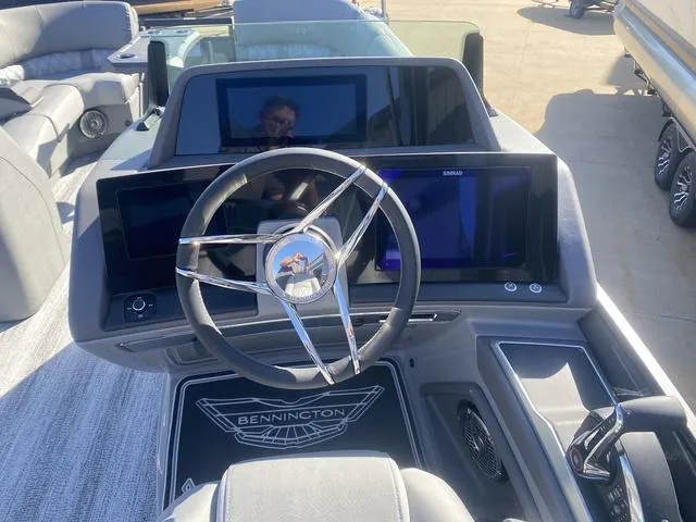 Slide: The Image of 2025 Bennington 25 QFBA boat dashboard with steering wheel and digital displays. - 17