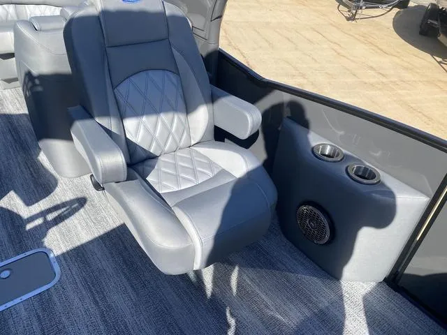 Slide: The Image of 2025 Bennington 25 QFBA boat interior with gray captain's chair and cup holders. - 21