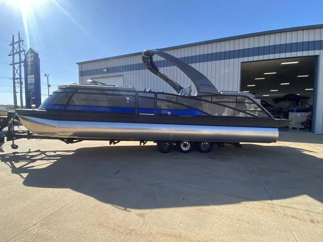 Slide: The Image of 2025 Bennington 25 QFBA pontoon boat parked outside a warehouse. - 4