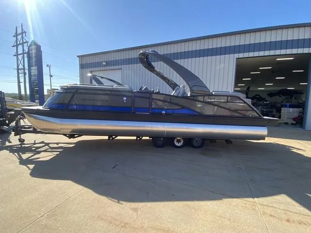 Slide: The Image of 2025 Bennington 25 QFBA pontoon boat parked outside a warehouse. - 5