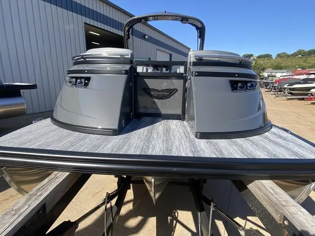Slide: The Image of 2025 Bennington 25 QFBA pontoon boat with sleek gray design at a marina. - 7