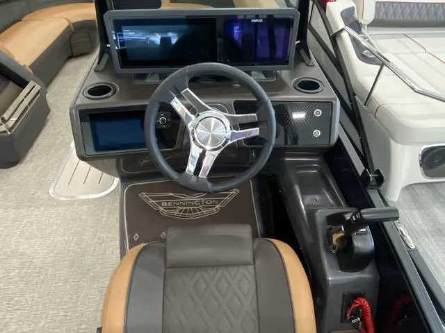 Slide: The Image of 2025 Bennington 24' MSB Tri-Toon helm with modern steering wheel and dual displays. - 22