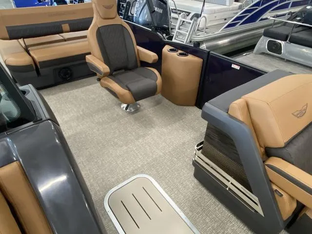Slide: The Image of 2025 Bennington 24' MSB Tri-Toon interior with tan and gray seating, luxurious design. - 25