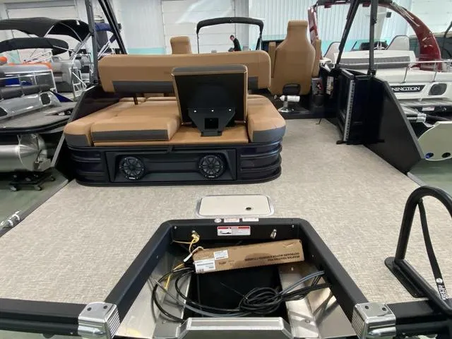 Slide: The Image of 2025 Bennington 24' MSB Tri-Toon interior with seating and storage area. - 9