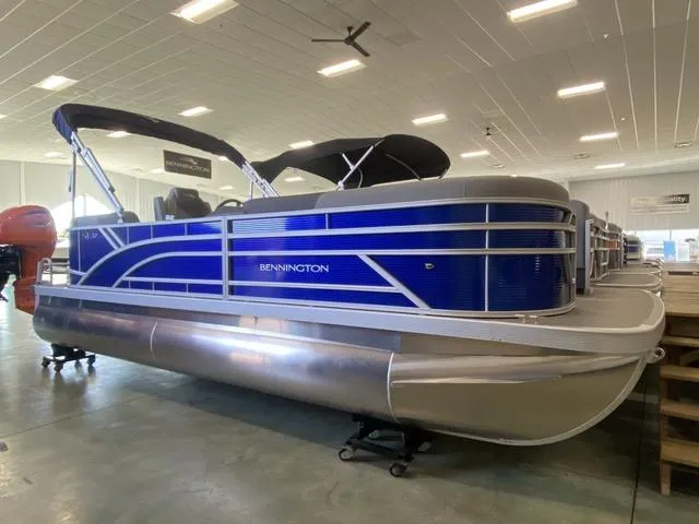 Slide: The Image of 2024 Bennington 20 SVSR-SPS pontoon boat in vibrant blue, parked outdoors. - 1