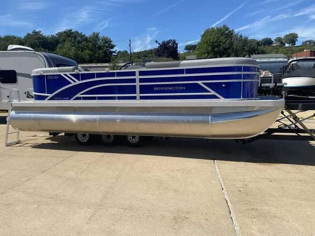 Slide: The Image of 2024 Bennington 20 SVSR-SPS pontoon boat on trailer, blue exterior, sunny day. - 3
