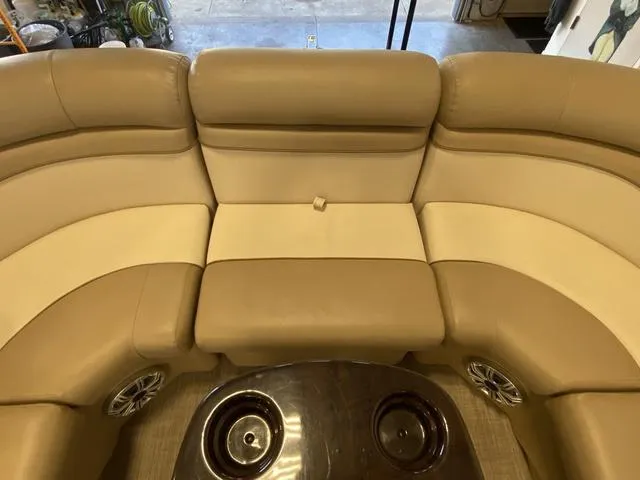 Slide: The Image of 2016 Bennington 24 SSRX boat interior with beige seating and cup holders. - 11