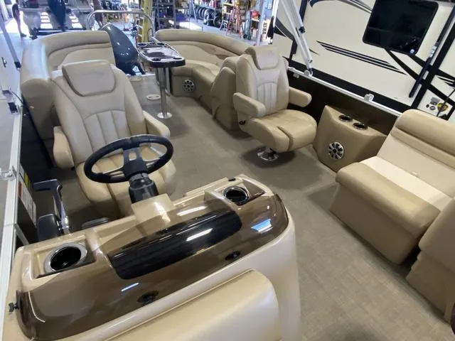 Slide: The Image of 2016 Bennington 24 SSRX boat interior with beige seating and steering wheel. - 13