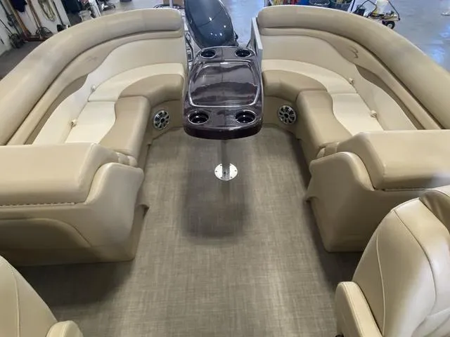 Slide: The Image of Interior of a 2016 Bennington 24 SSRX pontoon boat with beige seating and central table. - 16
