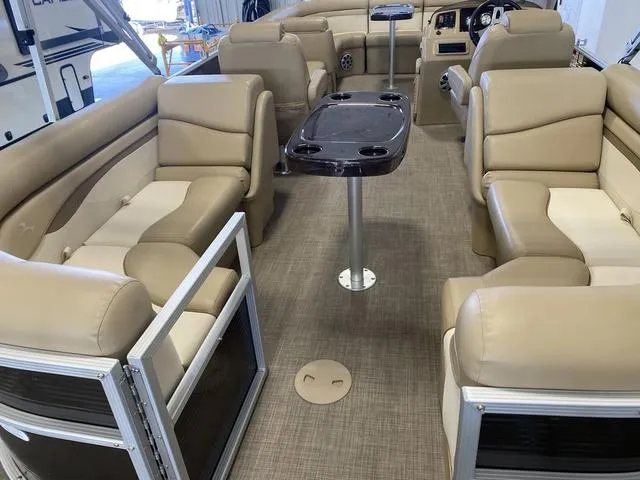 Slide: The Image of 2016 Bennington 24 SSRX pontoon boat interior with beige seating and central table. - 17